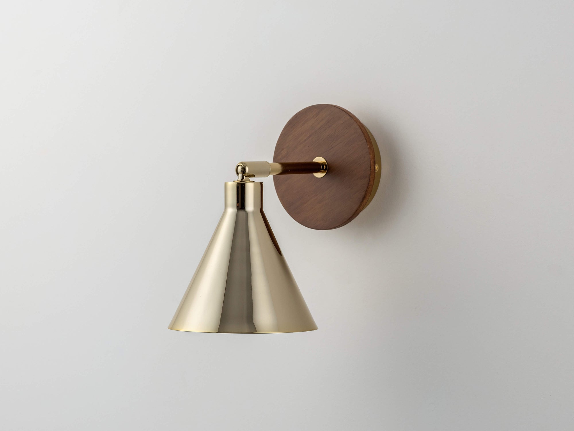 An adjustable brass metal cone shade is attached to a wood veneer wall fixture. Light is off. hover-image