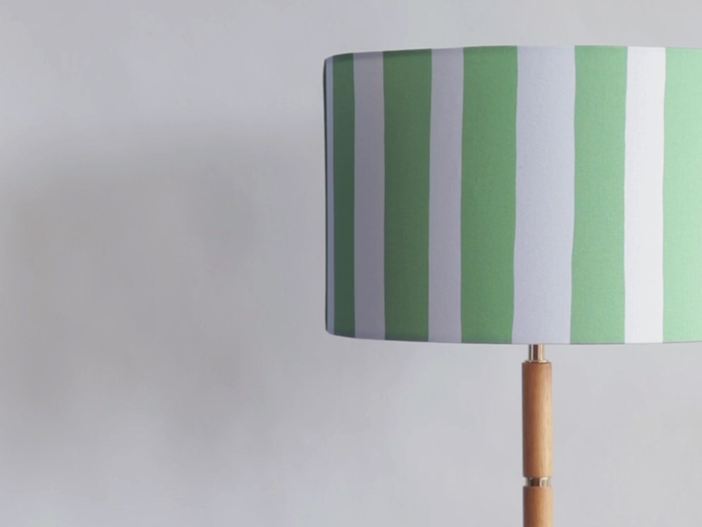 Cotton canvas 35cm drum lampshades with a digitally printed thick, slightly-wobbly vertical blue and green stripe pattern.