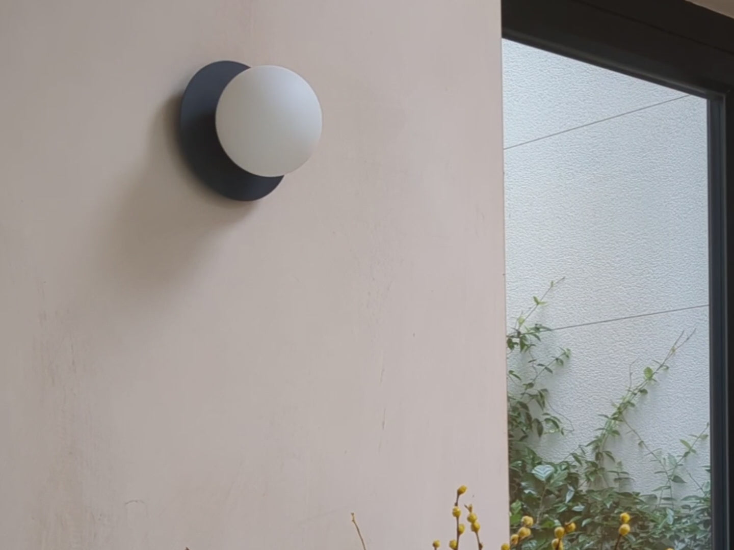 An opal glass shade sits upon a charcoal-grey coloured metal disk. Suitable for bathrooms.